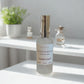Cozy Scents 'Clean Calm' serum bottle on a white surface with a blurred background.
